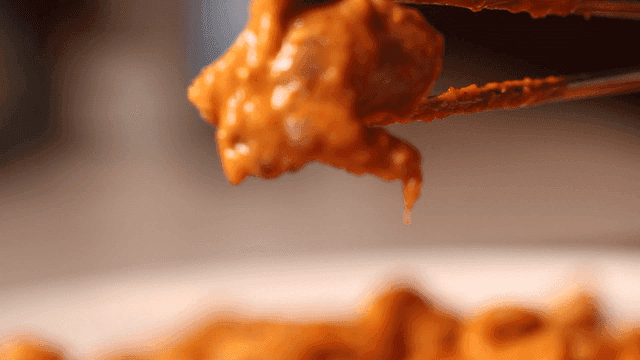 Spicy Rosé Braised Chicken picked up with chopsticks