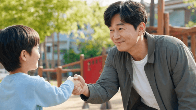Father and son shaking hands in park