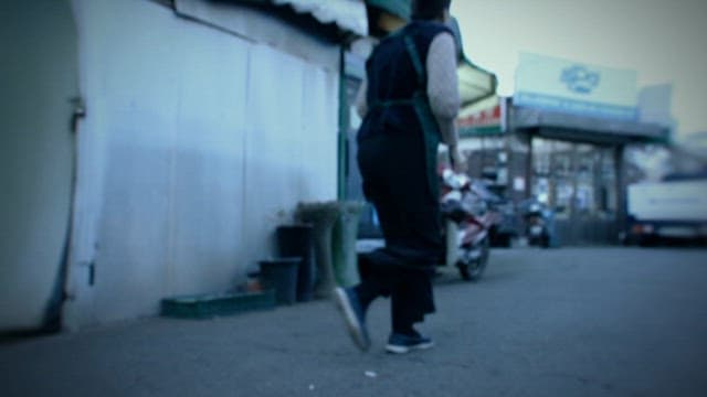 도시의 상가 골목을 두리번거리며 뛰어다니는 사람