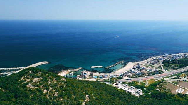 맑은 바다와 초록 언덕이 있는 해안 마을