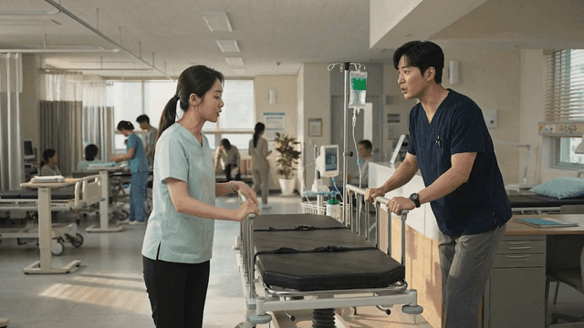 Medical staff moving beds in ward