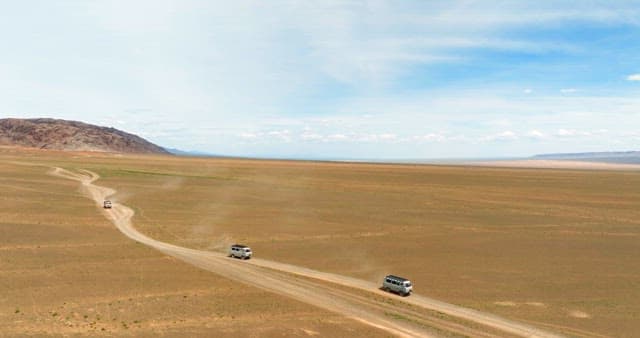 Vans traveling through a vast desert landscape