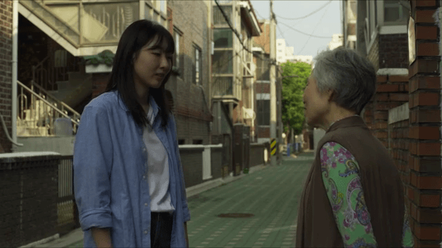 조용한 골목에서 대화하는 두 여성