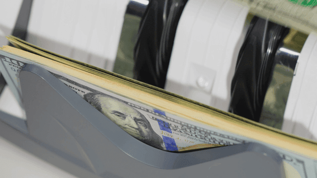 지폐 계수기가 달러를 세는 모습