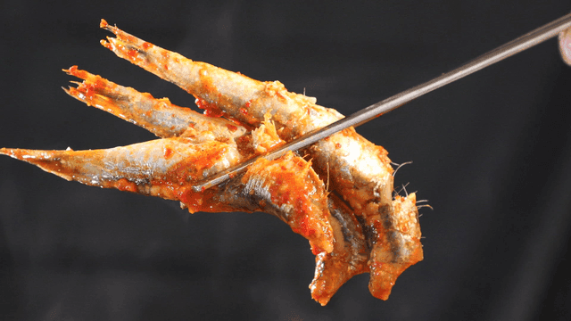 Spicy anchovy stew with fish lifted with chopsticks