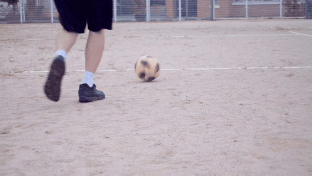 흙바닥에서 축구를 하는 사람