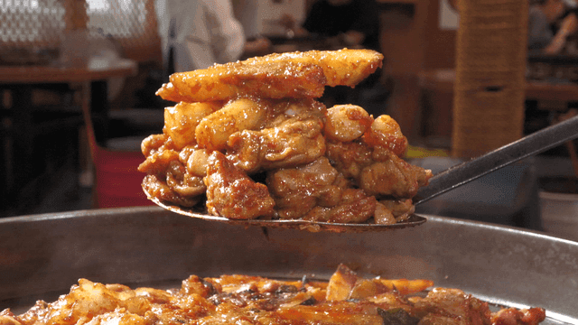 Spicy stir-fried chicken scooped with a spatula