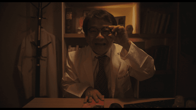 Doctor holding red envelope in dark office