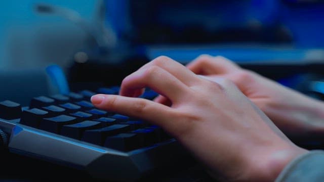 백라이트 키보드를 빠르게 타이핑하는 손