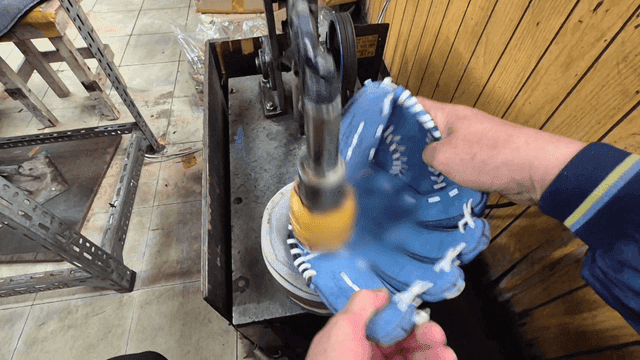 Craftsman polishing baseball gloves with machine