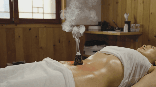 Woman receiving moxibustion treatment