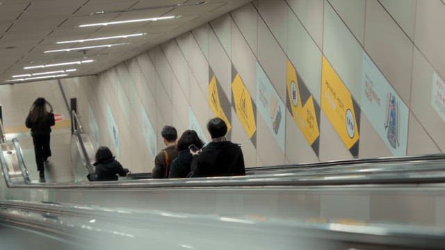 People descending an escalator in a subway