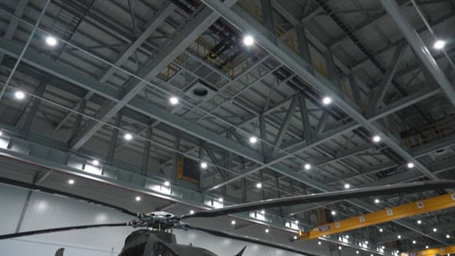 Helicopter inside an indoor hangar with bright lights