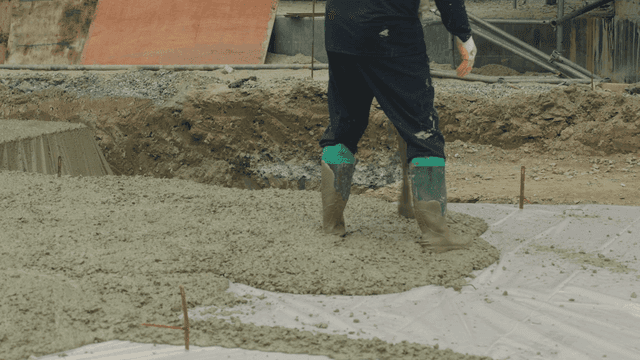 Worker pouring concrete at a construction site