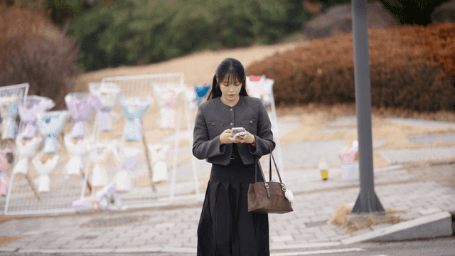 Woman walking down street looking at her cell phone
