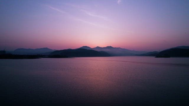 Serene Sunset over Tranquil Lake and Hills