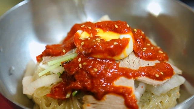 정갈하게 담긴 면 요리 위에 끼얹어지는 소스