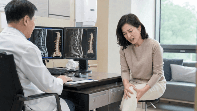 Female patient consulting doctor about knee pain
