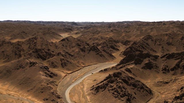 Winding road through a vast desert landscape