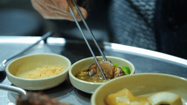 숯불 갈비를 소스에 찍는 장면