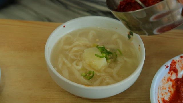 면이 들어간 닭고기 국물에 매콤한 양념장 추가