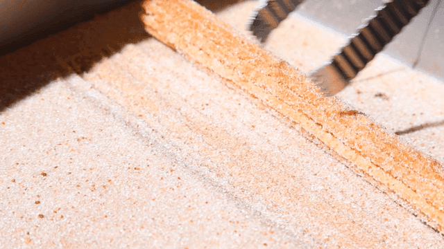 Churros being coated with sugar