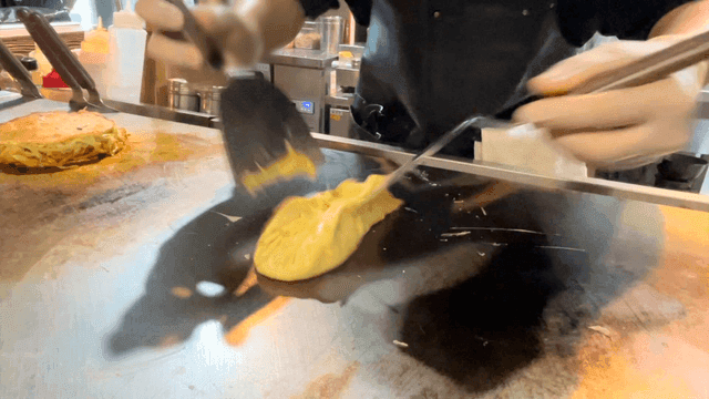 Chef preparing omelette on a hot griddle