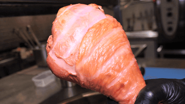 Chef holding smoked turkey legs in kitchen