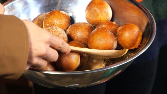 Covering freshly fried glutinous rice donuts with sugar