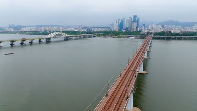 강 위의 다리를 건너가는 도시의 지하철 열차