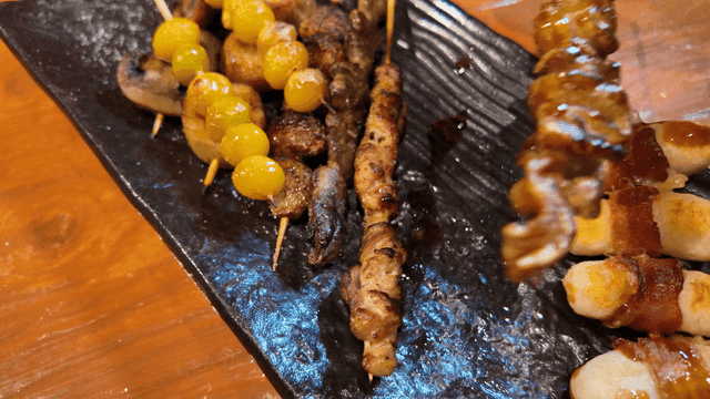Assorted skewers on black plate