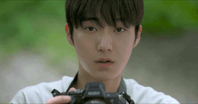 숲에서 카메라를 들고 있는 젊은 남성