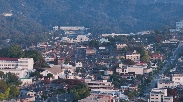 Village of densely packed Hanok houses spread out beneath the mountainside