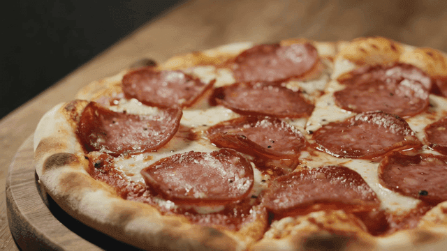 Delicious pepperoni pizza on a wooden board