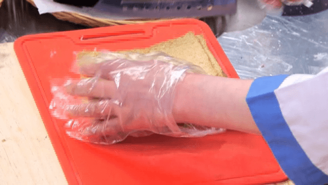 Slicing fish cake on a red cutting board