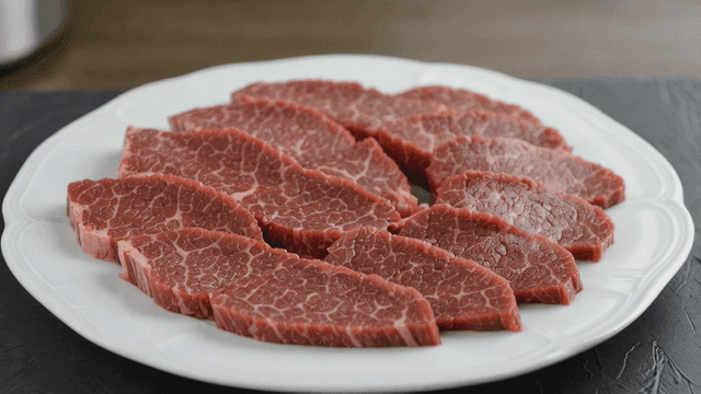 Slices of raw beef on a white plate