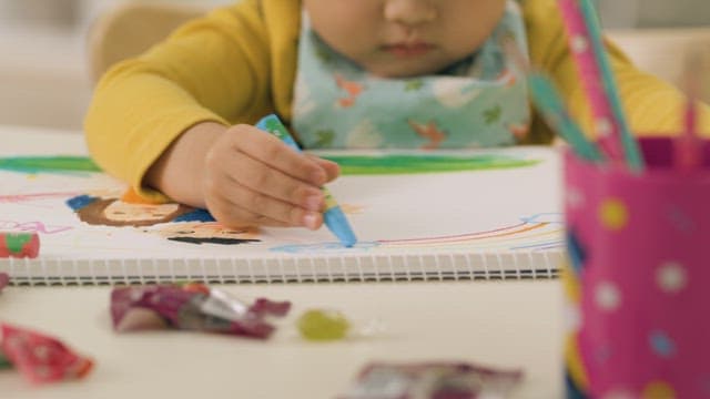 Child Focused on Drawing with Crayons