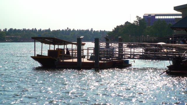 Dock with boat anchored on the river, sparkling in the sunlight