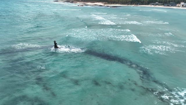 Statue in the ocean with waves