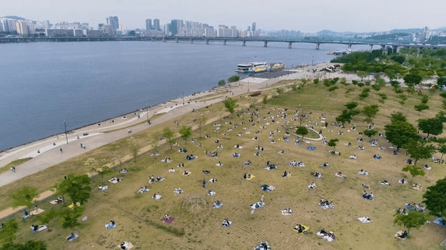 여유로이 휴식을 취하는 사람들이 있는 강변 공원