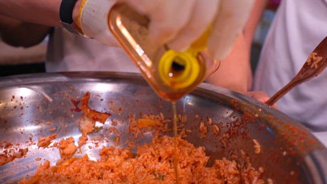 무생채 비빔밥에 참기름을 추가하는 모습