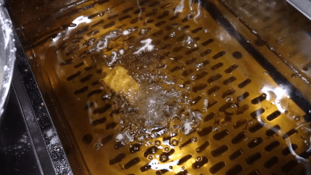 Ice cream coated in batter being fried