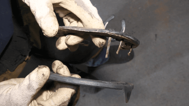 Worker holding metal parts in gloves