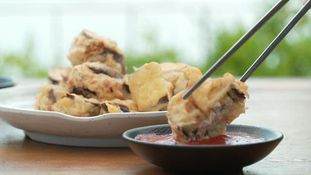 Crispy fried eggplant dipped in sauce