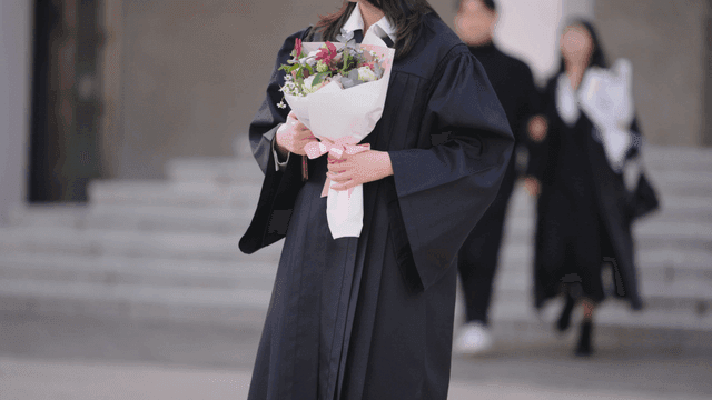 Graduate holding a bouquet of flowers