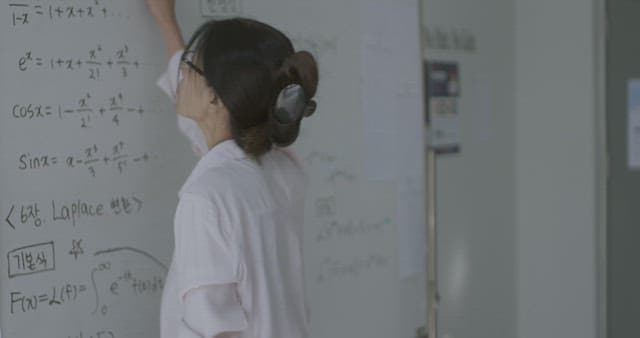 화이트보드에 적힌 판서를 지우는 선생님