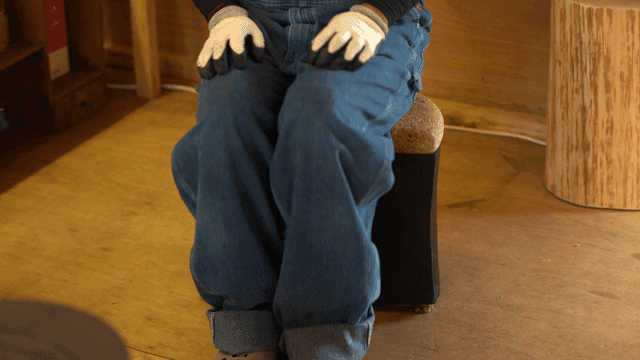 작은 코르크 나무 의자에 앉아 있는 사람