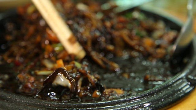 김이 모락모락 나는 철판 해물짜장면 한 젓가락