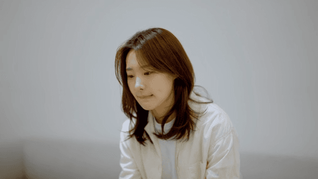 소파에 앉아 초조하게 무언가를 기다리는 여성
