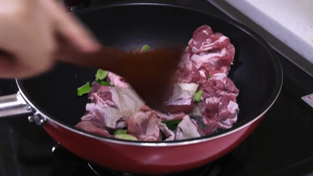 팬에서 고기와 채소를 볶는 장면